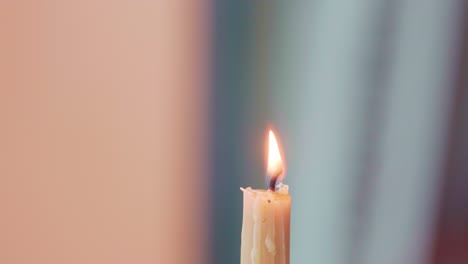 Closeup-on-Artist's-Hand-Holding-a-Wax-Stylus-in-a-Candle-Flame