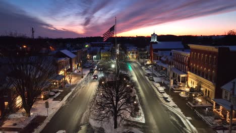 American-flag-waving-in-snowy-small-town-square-during-sunset