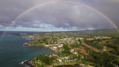 Grey-cloudy-skies-and-perfect-rainbow-above-Hawaiian-bay-and-tropical-hotels