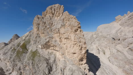 FPV-drone-rising-up-Italian-Dolomite-mountain-range-preparing-to-dive-breath-taking-rocky-ridge