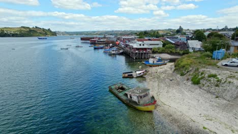 Drone-flying-along-the-coastline-Dalcahue-city,-daytime-in-Chiloé,-Patagonia,-Chile