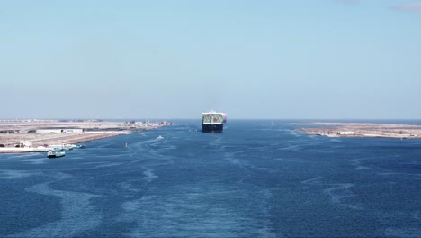 Wide-shot-of-a-large-container-vessel-entering-Suez-canal-in-Port-Said