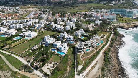 Luxury-villas-along-the-coastline-with-pools-in-cyprus,-sunny-day,-aerial-view