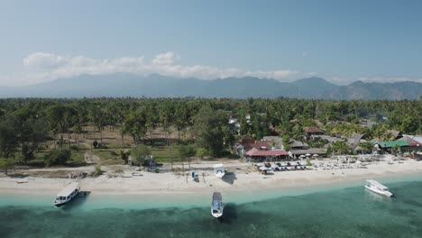 Zoom-out-aerial-shot-of-a-beach-with-forest-and-range-of-mountains-at-background-in-Thailand
