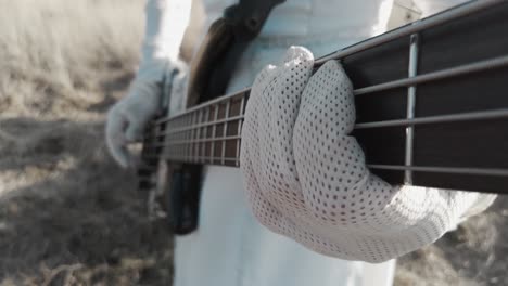Nahaufnahme-Eines-Mannes,-Der-E-Gitarre-Spielt,-Während-Er-Draußen-Weiße-Handschuhe-Und-Kleidung-Trägt