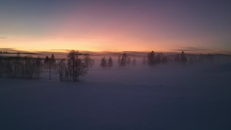 Snow-covered-landscape-at-dawn-with-fog-and-silhouetted-trees-near-Sundsvall,-Sweden