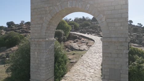 Drone-flies-through-stone-archway-entrance-to-historical-Spanish-holy-basilica-landmark