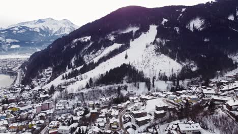 Ski-slope-trail-in-Austrian-town-of-Zell-Am-See,-aerial-drone-view,-4k,-day