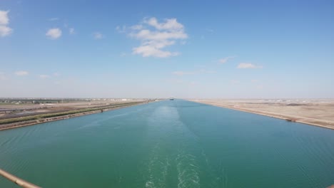 Zeitraffer-Eines-Schiffes,-Das-An-Einem-Sonnigen-Tag-In-Der-Wüste-Durch-Den-Suezkanal-Fährt