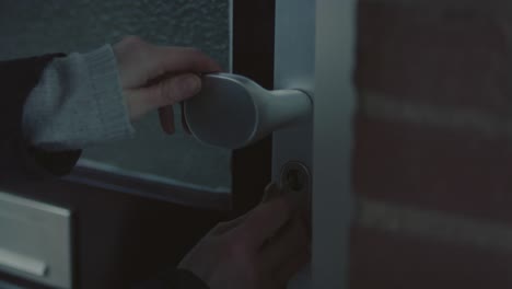 Close-up-of-girl-putting-key-in-lock-of-front-door-and-walking-inside