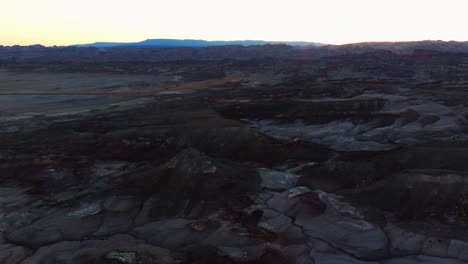 Drone-tilt-down-view-of-Bentonite-Hills-landscape-at-twilight,-Utah-in-USA