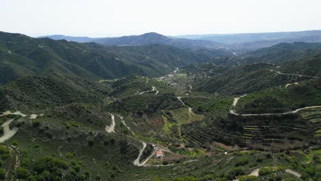 Üppige-Grüne-Berglandschaft-Zyperns-Mit-Kurvenreichen-Straßen-Und-Verstreuten-Häusern,-Luftaufnahme