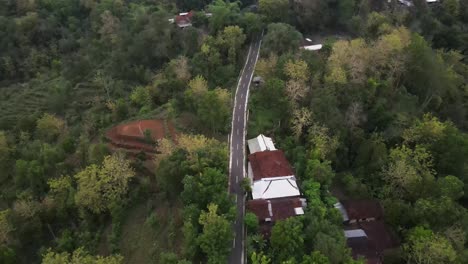 Luftaufnahme,-Radfahrer-Fahren-Bergauf-Durch-Eine-Kurvenreiche-Straße-Mit-Dichtem-Wald