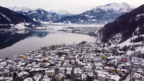 Aerial-view-of-Zell-am-See-in-Austria,-winter-wonderland,-pull-back,-day