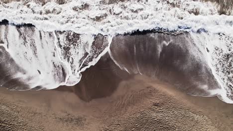 Ocean-waves-crashing-on-deserted-sandy-beach,-Plage-de-Grande-Anse-bay,-Guadeloupe,-French-Antilles