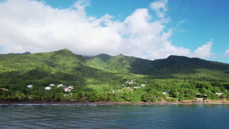 Drohne-Fliegt-über-Das-Meerwasser-In-Richtung-Des-Strandes-Plage-De-Grande-Anse-Mit-üppigem-Wald-Im-Hintergrund,-Guadeloupe