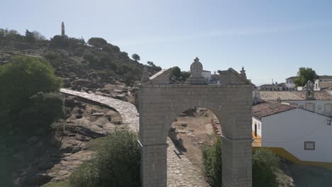 Stone-arch-entrance-gate-to-Our-lady-of-Cabeza-Spanish-hilltop-shrine-Andalusia-DRONE-ORBITAL