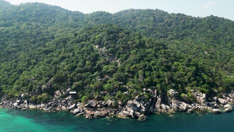 Mango-Bay-in-Ko-Tao-Island-Thailand-seaside-resort-with-rocky-shoreline-cabins,-Aerial-approach-shot