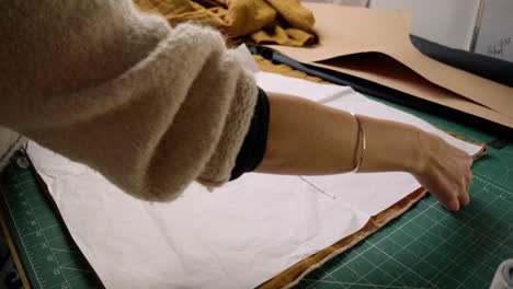 Wide-shot-of-slow-fashion-clothing-maker-placing-sewing-templates-on-fabric-preparing-to-cut