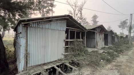 Cinematic-profile-view-of-multiple-aluminum-abandoned-huts-in-a-row-during-evening-in-Kolkata,-India