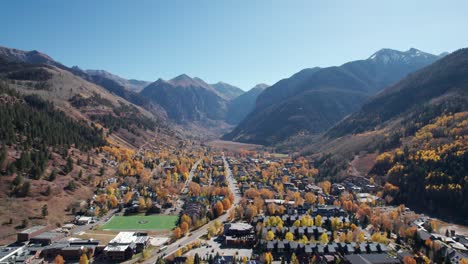 Distant-pullback-drone-shot-of-downtown-Telluride,-CO-with-fall-colors