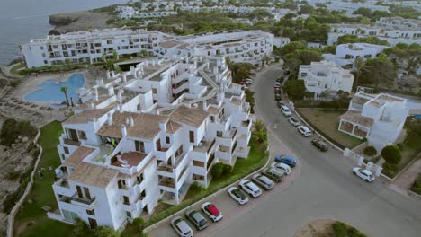 A-rotating-aerial-view-captures-a-complex-of-tourist-accommodation-buildings-situated-along-the-coastline-of-Mallorca,-Spain,-embodying-the-concepts-of-tourism-and-vacation