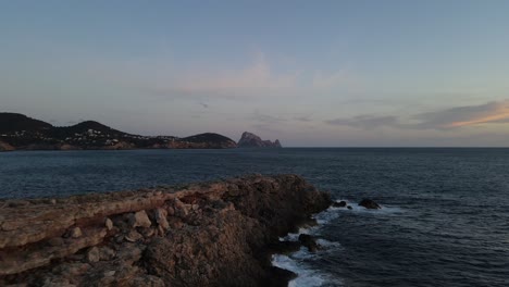 Drohnenansicht-Einer-Klippe-über-Dem-Meer-Mit-Dem-Unglaublichen-Hintergrund-Der-Insel-Es-VedrÁ-Auf-Ibiza