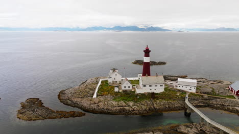 Guest-houses-built-up-around-lighthouse-on-historic-islands-of-Norway,-aerial-orbit