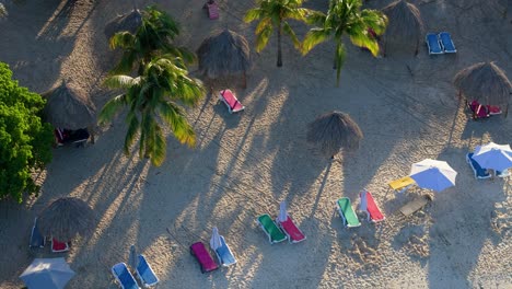 Lebhafte,-Schöne-Farbige-Liegestühle-Und-Tropische-Palmenschirme-Am-Karibischen-Strand