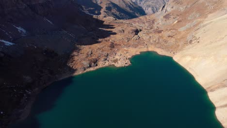 drone-shot-panning-up-revealing-the-large-lake-placed-in-the-valley-of-a-mountain
