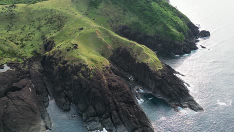 The-lush-green-coastline-of-baras-in-catanduanes,-with-cliffs-descending-into-the-sea,-aerial-view