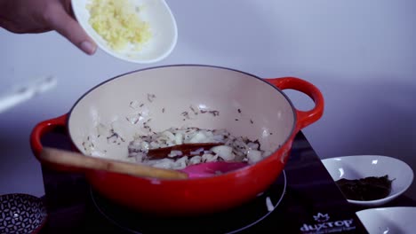 Agregar-Ajo-Fresco-Picado-A-Una-Olla-De-Hierro-Fundido-Con-Ingredientes-Para-Cocinar-Curry-De-Papaya-Verde-Fresco