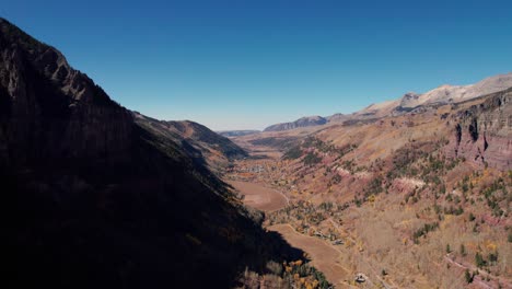 Very-distant-drone-shot-showing-all-of-Telluride,-Colorado-in-the-mountain-valley