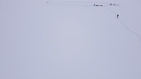 Disparo-Aéreo-De-Un-Dron-Volando-Sobre-Un-Paisaje-Montañoso-Cubierto-De-Nieve-Blanca