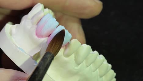 Dental-technician-carefully-apply-ceramic-layers-shades-on-gypsum-cast,-esthetic-dentistry