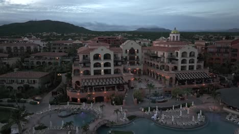 Hacienda-Del-Mar,-Los-Cabos,-Mexico-at-dusk---descending-aerial-view-of-resort,-landscape,-pools