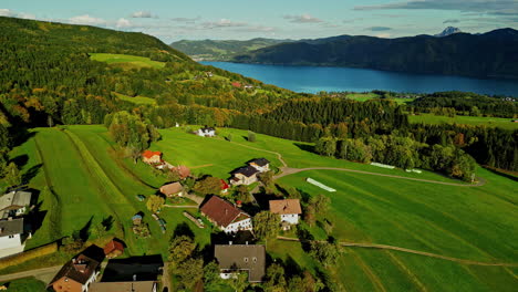 Aerial-view-of-Austrian-countryside-with-Lake-Atter-in-the-background,-sunlight-over-the-valley