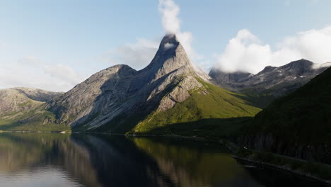 Curved-mountain-bares-to-grey-peak-with-clouds-gathered-at-top,-Stetind-Norway