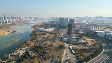 Aerial-view-of-downtown-Linyi-in-Shandong-Province,-China-with-the-Benghe-River-and-Art-Museum-in-the-background-of-the-city-skyline