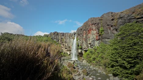 Beautiful-Taranaki-waterfall-dropping-off-volcanic-cliff-on-sunny-day
