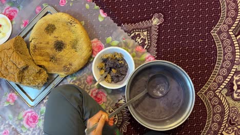 Serving-traditional-local-food-persian-cuisine-iranian-local-people-eat-delicious-Qurut-Kashk-the-dairy-base-food-with-fried-eggplant-and-tomato-soak-dry-bread-in-bowl-dinner-time-in-Iran-countryside