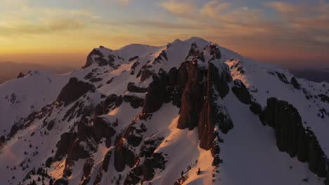 Sonnenuntergang-über-Den-Schneebedeckten-Ciucas-Bergen-Mit-Orangefarbenen-Farbtönen-Am-Himmel