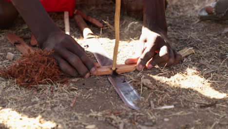 Ausgeschnittene-Ansicht-Eines-Masai-Männers,-Der-In-Einem-Dorf-In-Der-Masai-Mara,-Kenia,-Mit-Der-Handübung-Feuer-Macht