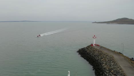 Small-boat-approaching-Howth's-harbour.--Aerial-static-shot