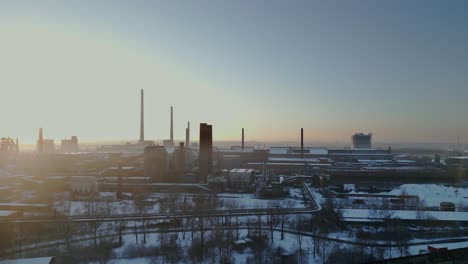 Expansive,-snow-covered-industrial-complex-bathed-in-the-soft-glow-of-a-sunrise-or-sunset