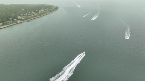 Drone-shot-of-powerboats-traveling-along-the-coast-of-Massachusetts