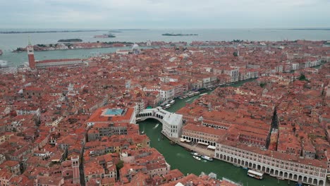 Rialto-bridge-over-the-grand-canal-in-Venice,-showcasing-historic-architecture,-aerial-view