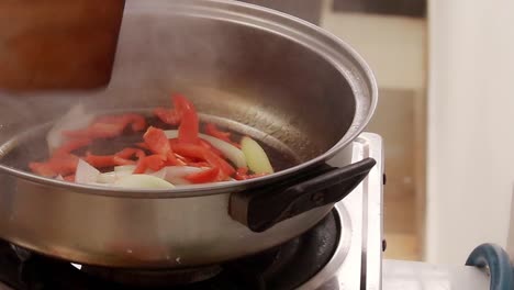 Sauteing-onions-and-red-paprika-on-a-hot-pan,-home-cooking-and-candid-daily-life