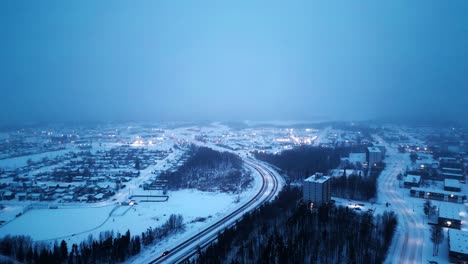 Establishing-Shot-4K-Sunrise-Blue-Hour-Morning-Cinematic-4K-Blizzard-Snowfall-Foggy-Glowing-Drone-Shot-of-Arctic-Winter-Community-Isolated-Remote-Mining-Village-Hub-of-North-Thompson-Manitoba-Canada