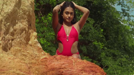 Embracing-the-warmth,-a-girl-of-Indian-descent-strolls-a-tropical-Caribbean-beach-in-a-red-bikini